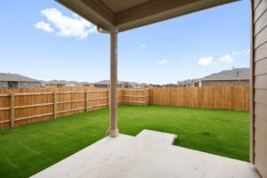 a spacious yard with wood fencing and green grass