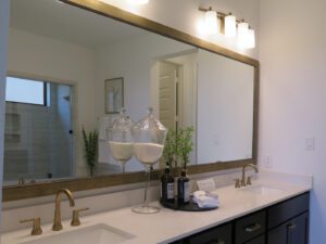 two kitchen sinks with a large wall mirror