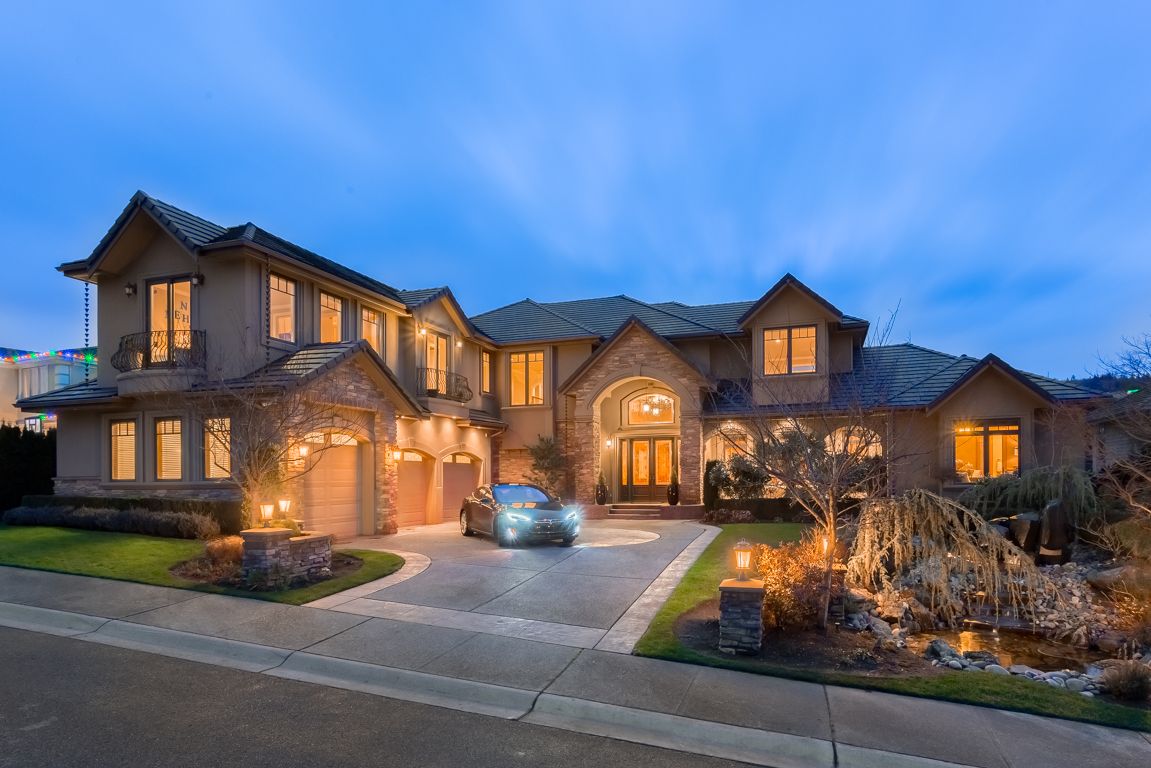 A large home with lights on the outside of it.
