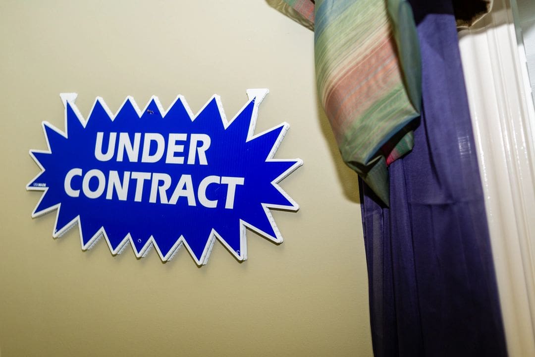 A sign that says under contract on the wall.