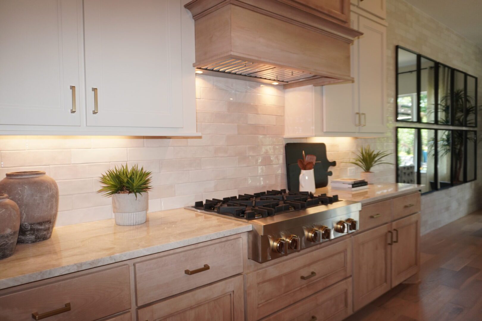 A kitchen with white cabinets and beige counters.