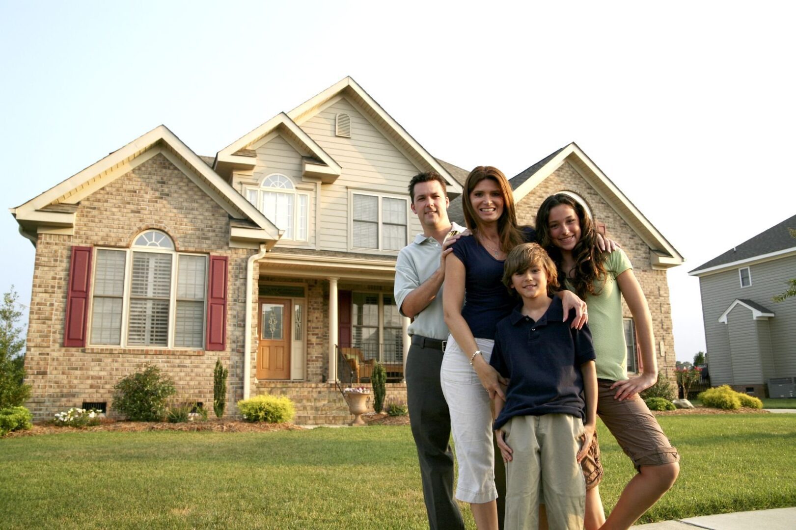 A family posing in front of their home.
