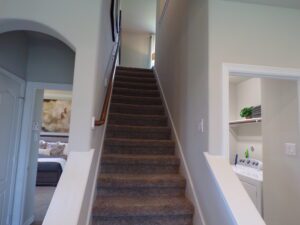 A stairway leading to a laundry room, constructed by Texas builders.