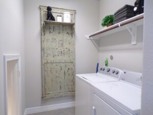 A laundry room with a built-in washer and dryer by Texas builders.