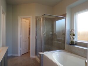 A bathroom with a glass shower stall and tub built by Texas builders.