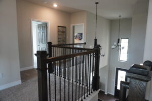A home staircase with a black railing built by Texas builders.