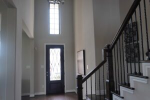 A stairway leading to a home built by Texas builders with hardwood floors and a light fixture.
