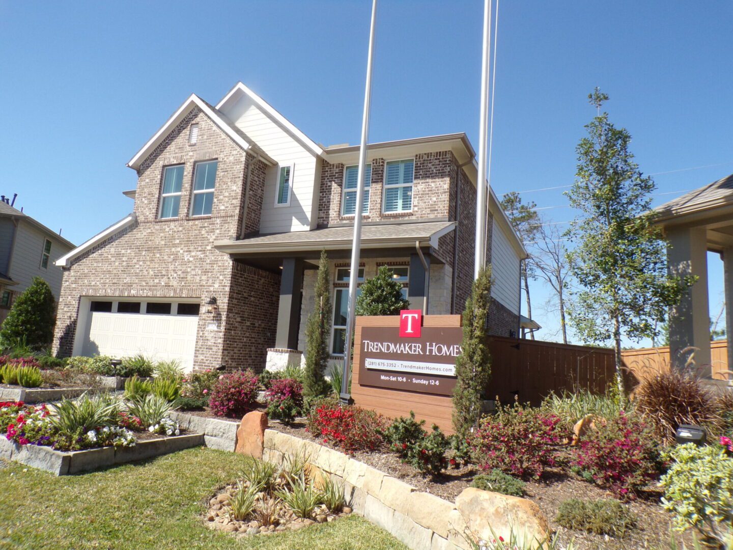 A new two-story brick house with a landscaped yard and a "Texas builders home" for sale sign in front.