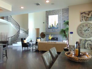 Modern living room with a spiral staircase, large brick wall decoration by Texas builders, leather sofa, and abstract wall art.