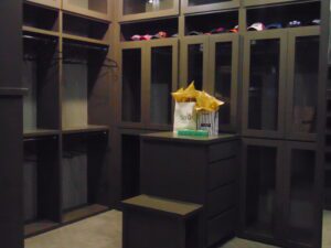 A dimly lit retail store with empty shelves and a sale sign on a gift-wrapped box in the center, constructed by Texas builders.