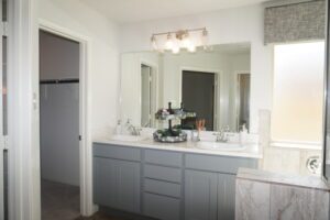 A modern bathroom with a double vanity, large mirrors, and soft lighting designed by Texas builders.