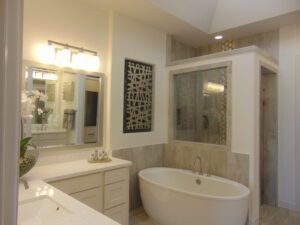 Spacious bathroom featuring a freestanding tub, dual vanity, and tiled shower stall, accented with decorative wall art and neutral tones, crafted by Texas builders.