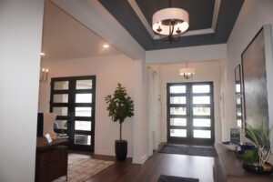 A hallway in a home with black doors and a light fixture designed by Texas builders.