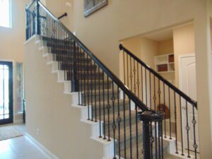 A stairway with both a black railing and a white railing, built by Texas builders.