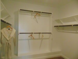 A walk-in closet with shelves built by Texas builders.