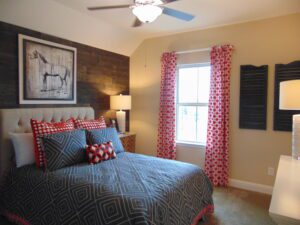A bedroom with a bed and a fan built by Texas builders.