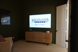 A living room with a TV on the wall, built by Texas builders.