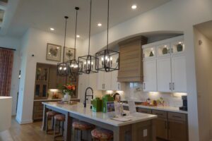 A kitchen designed and built by Texas builders with a large island and pendant lights.