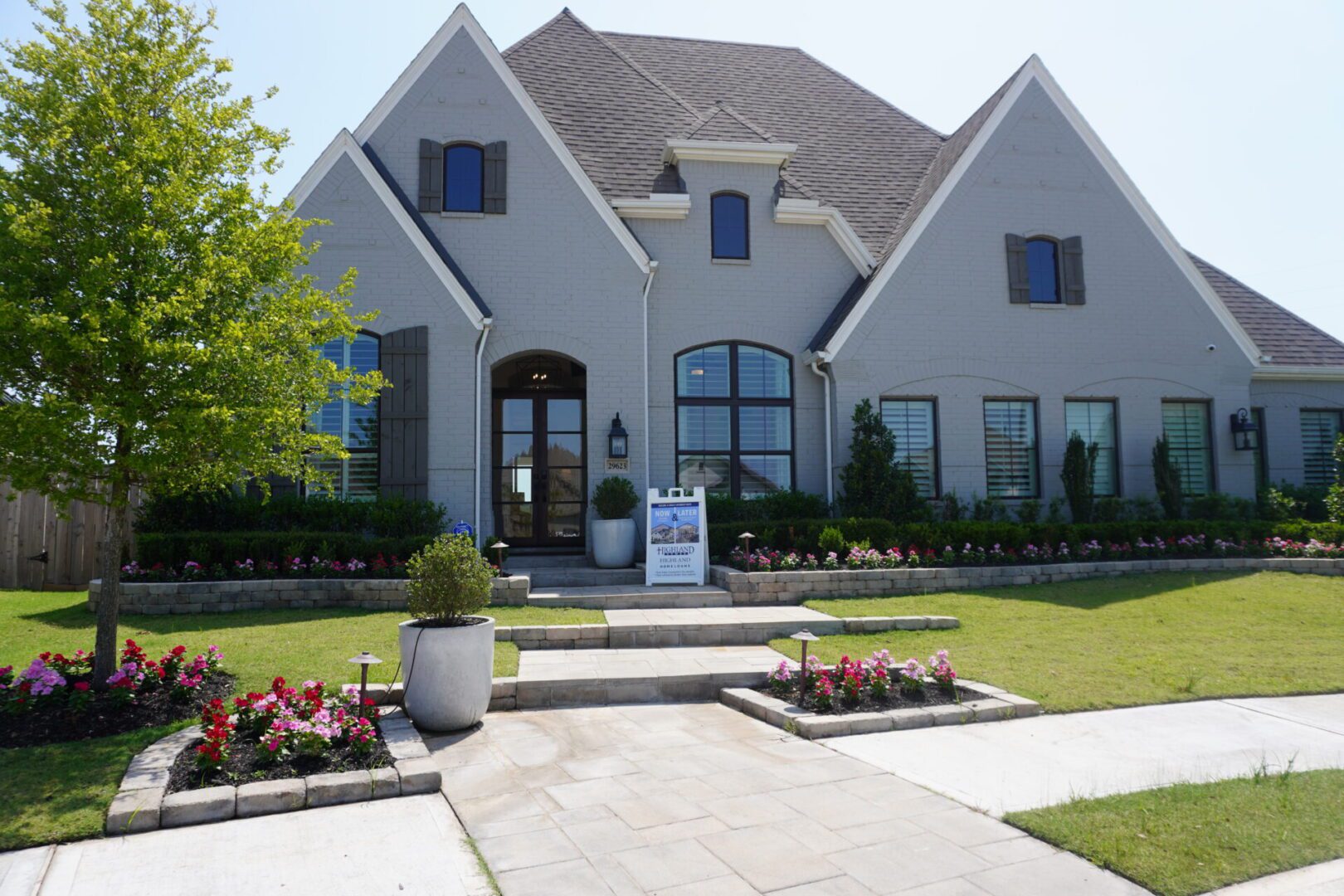 A home with a large front yard and landscaping, built by Texas builders.