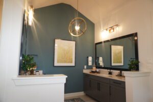 A bathroom with Texas builders, blue walls, and a light fixture.