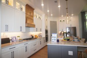 A kitchen with white cabinets and a center island, built by Texas builders.