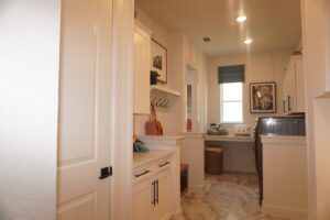 A white laundry room with a washer and dryer built by Texas builders.