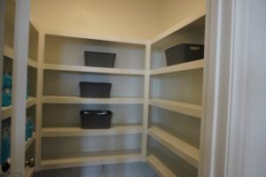 White shelves with gray storage bins.