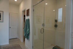 White tiled shower with glass doors.