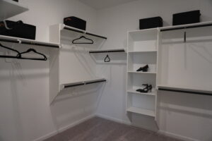 White closet with shelves and hangers.