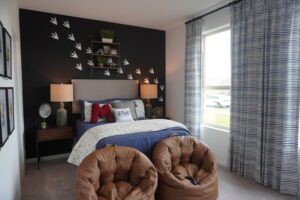 Bedroom with dinosaur footprints and beanbag chairs.